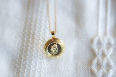 This locket necklace features a charming flower design and a flat circular shape. It serves as a keepsake for your most treasured memories, allowing you to insert a photo within it. Talk about a perfect gift idea! • How To Order1. Choose the size. 2. Select initials, if you do not want any initial, select "NONE"(UPPER CASE and HEART Shape Available) 3. Add to cart and submit order :) • Locket : Photo Frame Pendant, Flat Round with Flower, • Locket Size: about 0.79 inch x 0.89 inch • Initial Disk Circle Locket, Flower Circle, Studded Necklace, Pendent Necklace, Pearl Gemstone, Upper Case, Locket Necklace, Personalized Necklace, Flower Design