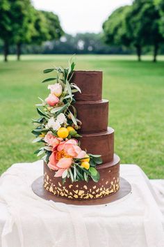 a three tiered chocolate cake with flowers on top