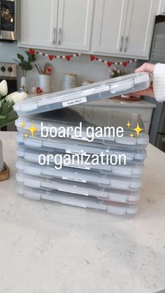 the board game organization bins are stacked on top of each other in front of a kitchen counter