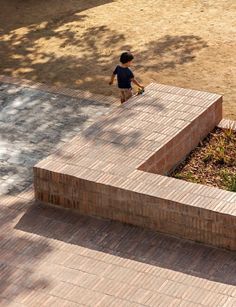 a young boy is walking down the sidewalk