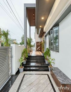 the entrance to a modern house with plants in pots