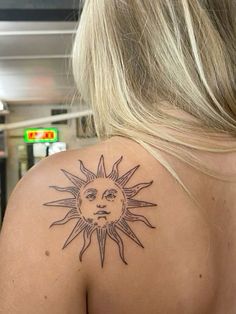 a woman with a sun tattoo on her back