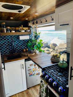 a kitchen area with an oven, stove and sink in the back ground next to the ocean