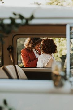 two women standing in the back of a truck