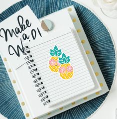 a notepad with a pineapple sticker on it next to a spiral notebook