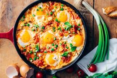 an egg casserole in a skillet on a wooden table with other ingredients