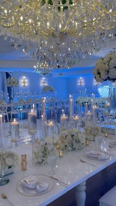 the table is set with white flowers and candles