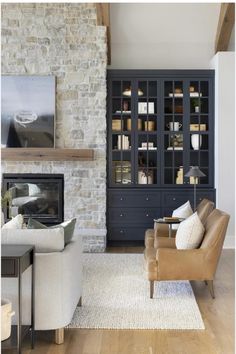 a living room filled with furniture and a fire place in front of a brick wall