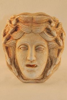 a sculpture of a woman's face with wavy hair