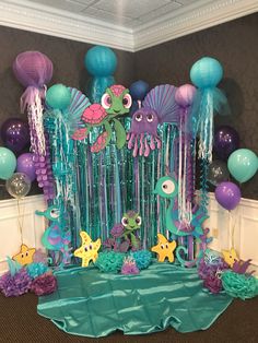 an under the sea themed birthday party with balloons, streamers and decorations on display