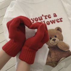 a person wearing red gloves and a t - shirt that says you're a flower