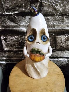 a ceramic figurine with blue eyes is sitting on top of a wooden table