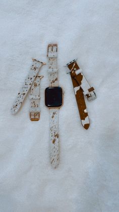 four watches are laying in the snow on top of each other and one is broken