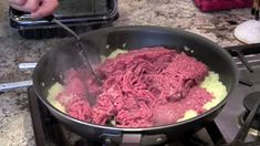 a pan filled with meat cooking on top of a stove