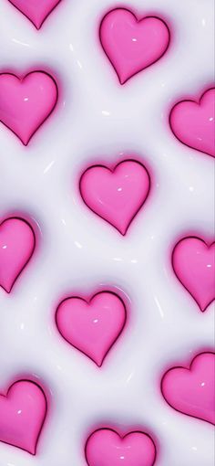 many pink hearts are arranged on a white surface