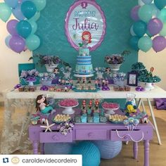 a purple table topped with lots of desserts and balloons