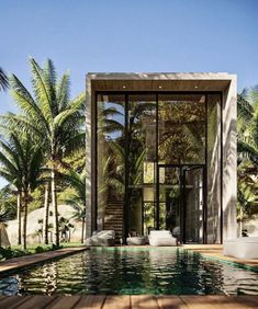 the pool is surrounded by palm trees and glass doors that lead to an outdoor lounge area