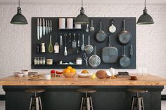 a kitchen with pots and pans hanging on the wall next to bar stools