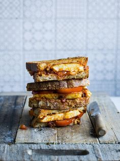 three grilled sandwiches stacked on top of each other with cheese and tomato in the middle