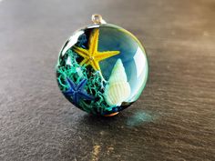 a glass ball with sea shells and starfish in it