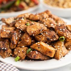 a white plate topped with chicken covered in sesame seeds