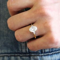 a person's hand with a ring on their finger and a diamond in the middle