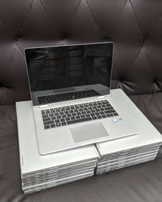 a stack of laptops sitting on top of each other in front of a couch