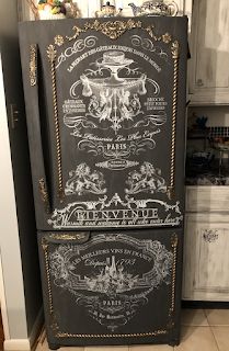 an old fashioned refrigerator is painted black with gold trimmings and ornate designs on the doors