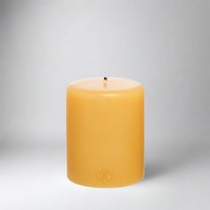 a yellow candle with the word h e on it's front and back side