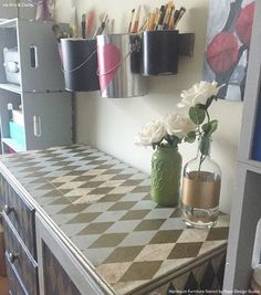 two vases filled with flowers sitting on top of a checkered counter