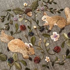 an embroidered fabric with flowers and rabbits on it