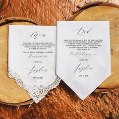 two white wedding handkerchiefs on top of a wooden table next to a piece of wood