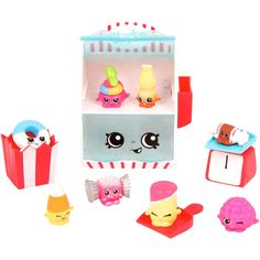 an assortment of small toys including a toy ice cream machine and other items on a white background