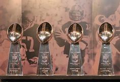 three football trophies sitting on top of a shelf