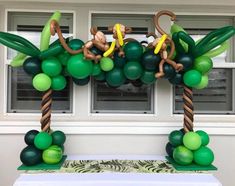 balloon decorations with monkeys and palm trees on the front porch for an outdoor birthday party