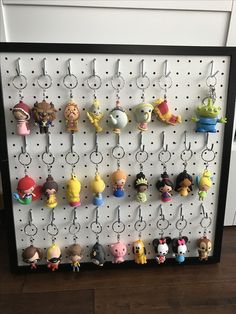 a peg board with many key chains hanging from it's sides and various cartoon characters on them