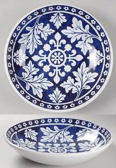 two blue and white plates sitting on top of each other in front of a gray background