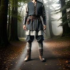 a man dressed in medieval clothing standing on a path