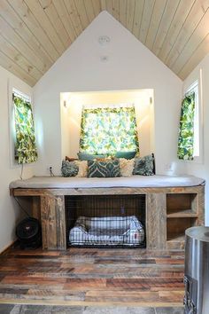 a dog bed in the middle of a room with wood flooring and white walls