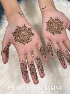 two hands with henna designs on them