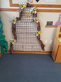 the wall is made out of cardboard and bees are on top of each other in front of it