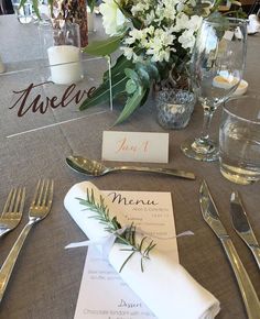 a table set with silverware, napkins and place cards for an elegant dinner