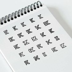 a spiral notebook with black and white arrows drawn on it's side, next to a pen