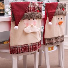 two christmas stockings sitting on top of white stools next to a table covered in snow