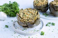 artichokes stuffed with bread and parmesan cheese on a white plate