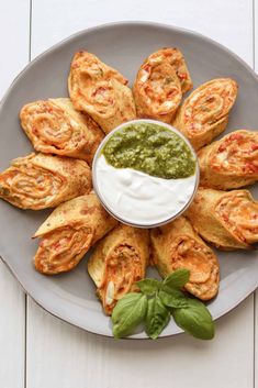 a white plate topped with pastries covered in guacamole and sour cream