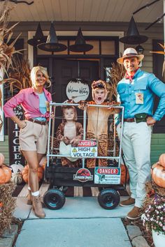 two people are standing in front of a store with pumpkins and scarecrows