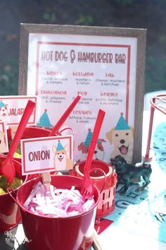 red buckets filled with candy sitting on top of a table next to a sign