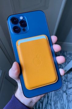 a person holding an apple phone in their hand with the case open and showing it's yellow interior