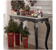 a table with potted plants on it in front of a christmas tree and other decorations